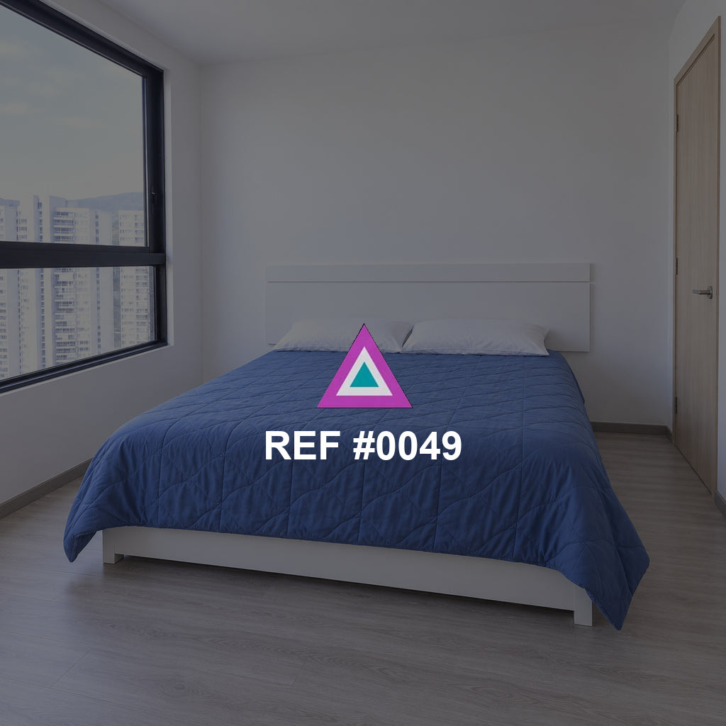 Azul junto a la Ventana. Una cama azul en un dormitorio luminoso, junto a una gran ventana.