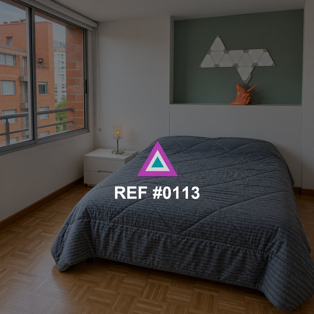 Geometría Azul. Una cama azul grisácea bajo un nicho verde y una figura geométrica blanca.