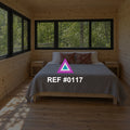 Refugio del Bosque. Una cama en una habitación revestida de madera, con ventanas abiertas hacia el verde.
