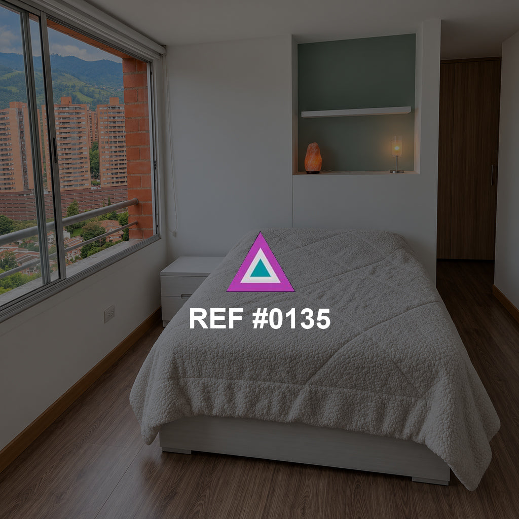 Ventana de Olivo. Una cama gris junto a una ventana urbana y un nicho de tono verde suave.