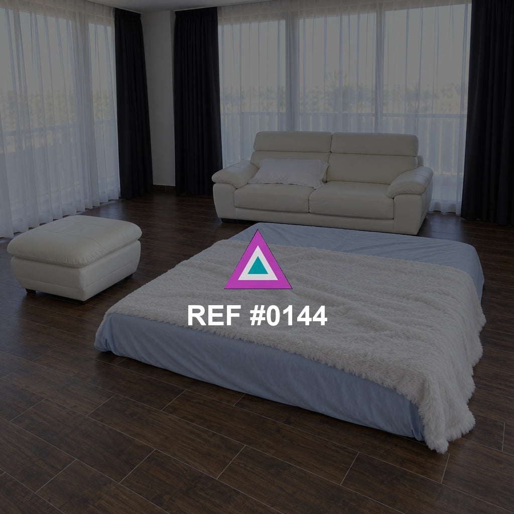 Salón de Descanso. Una cama baja y un sofá blanco conviven en una estancia amplia de cortinas claras.