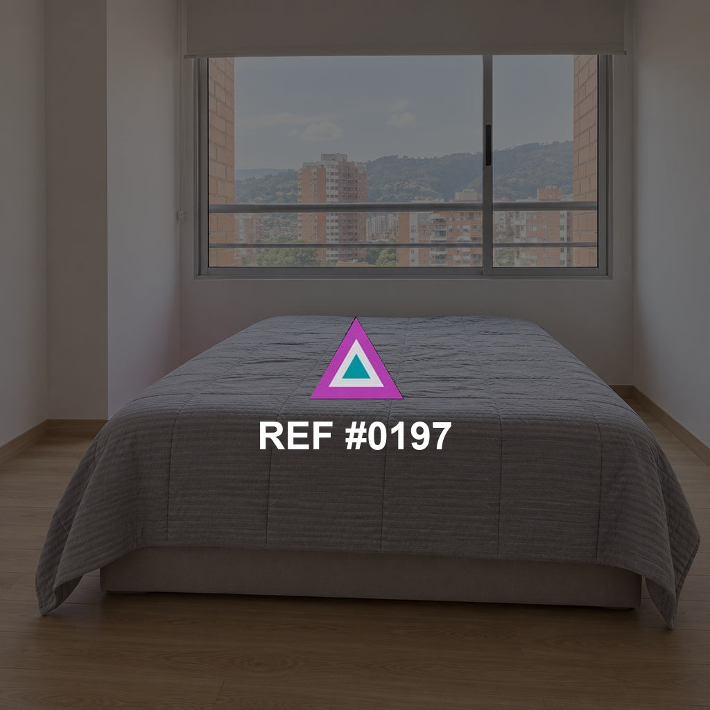 Ciudad en Reposo. Una cama gris junto a una ventana amplia que muestra edificios de la ciudad.
