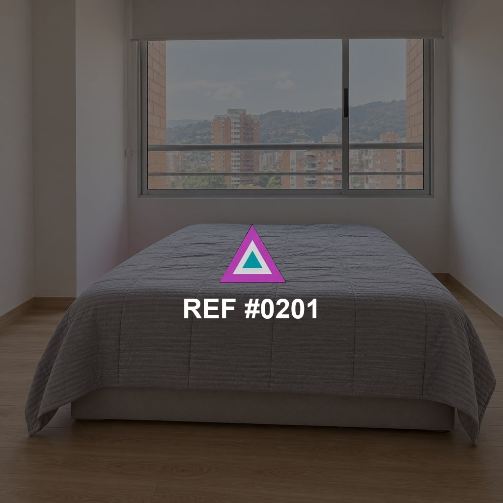 Ciudad en Reposo. Una cama gris junto a una ventana amplia que muestra edificios de la ciudad.