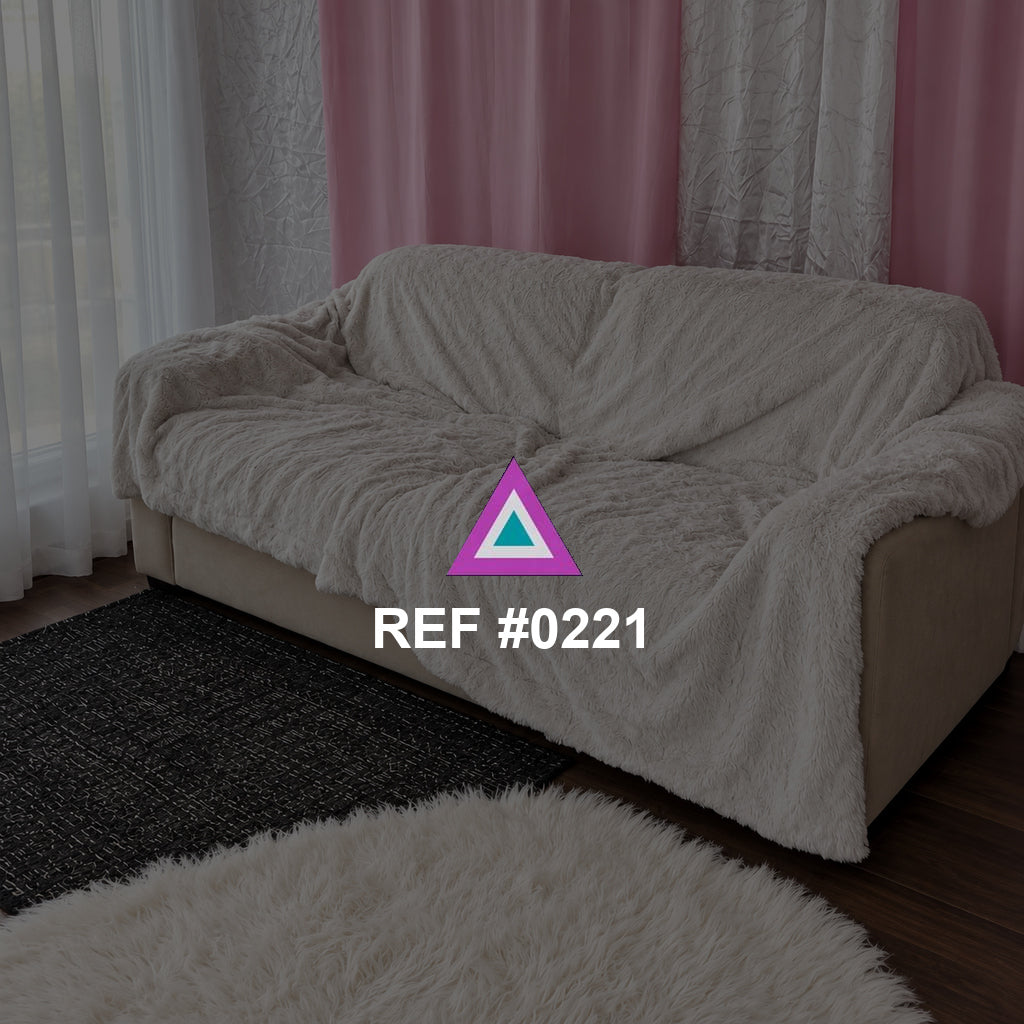 Pliegues de Rosa. Un sofá cubierto con tela clara frente a cortinas rosas y alfombras en blanco y negro.