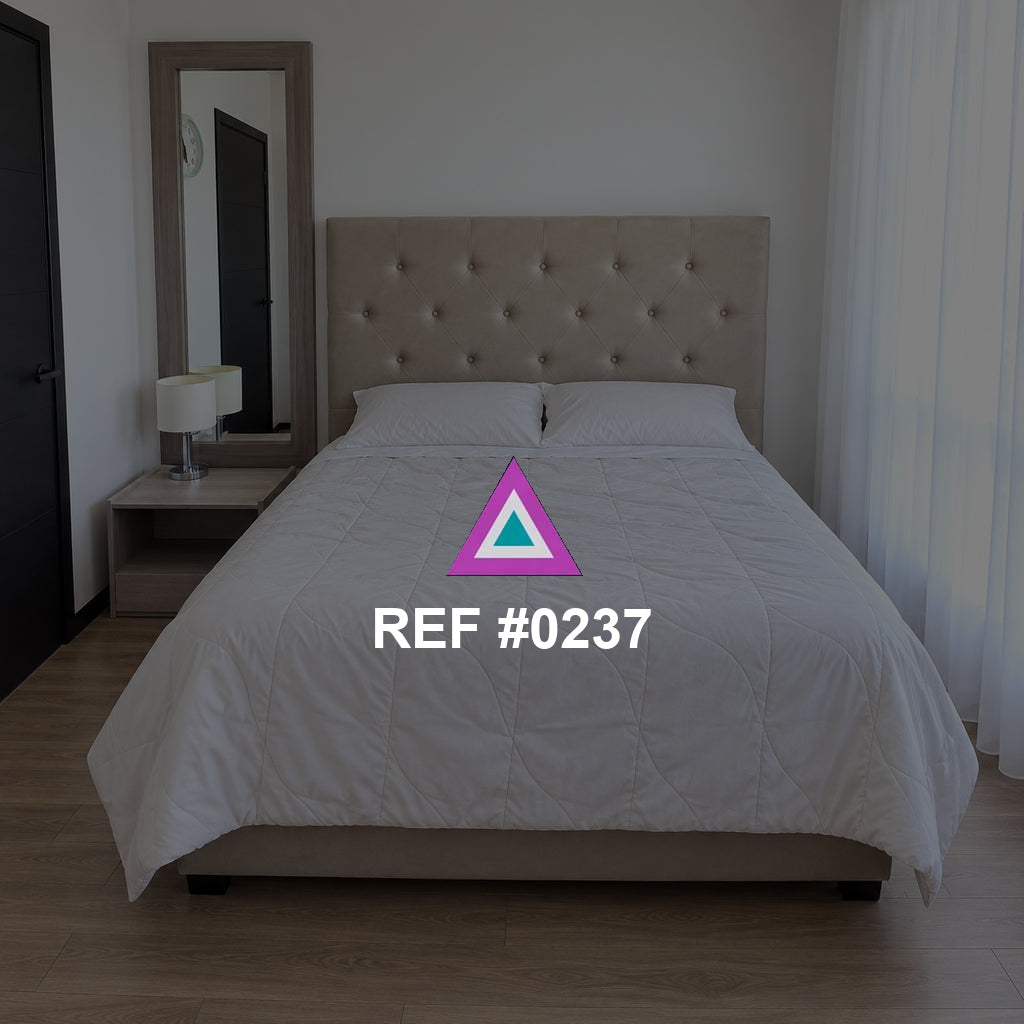 Umbral de Luz. Una cama clara de cabecera capitoné entre una puerta oscura y cortinas blancas.