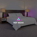 Dos Luces en Calma. Una cama blanca entre dos lámparas altas y un suave reflejo violeta en la pared.