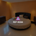 Círculo de Ámbar. Una cama redonda en una habitación de paredes anaranjadas y luz cálida.