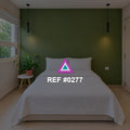 Verde en Silencio. Una cama blanca bajo una pared verde, con lámparas suspendidas y plantas.
