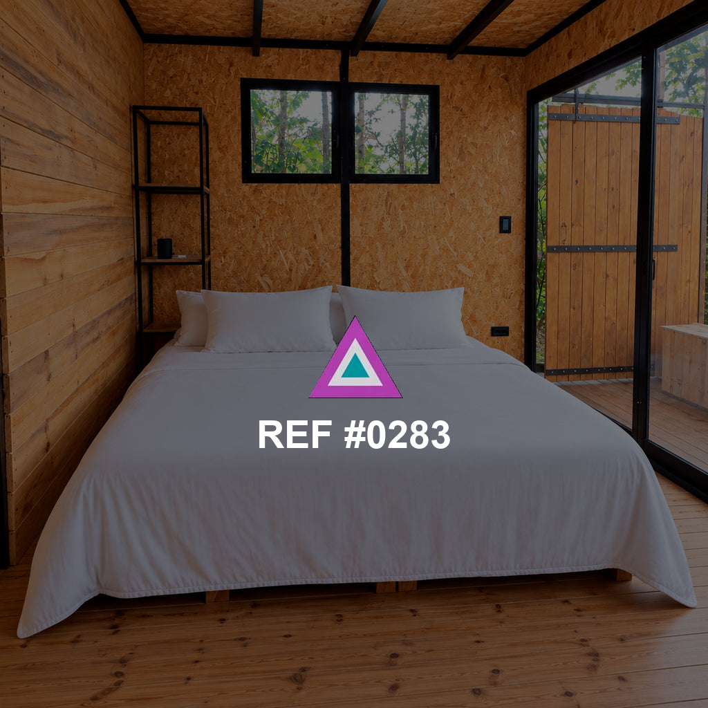La Cabaña Clara. Una cama blanca entre paredes y techos de madera, con ventanas enmarcadas en negro.
