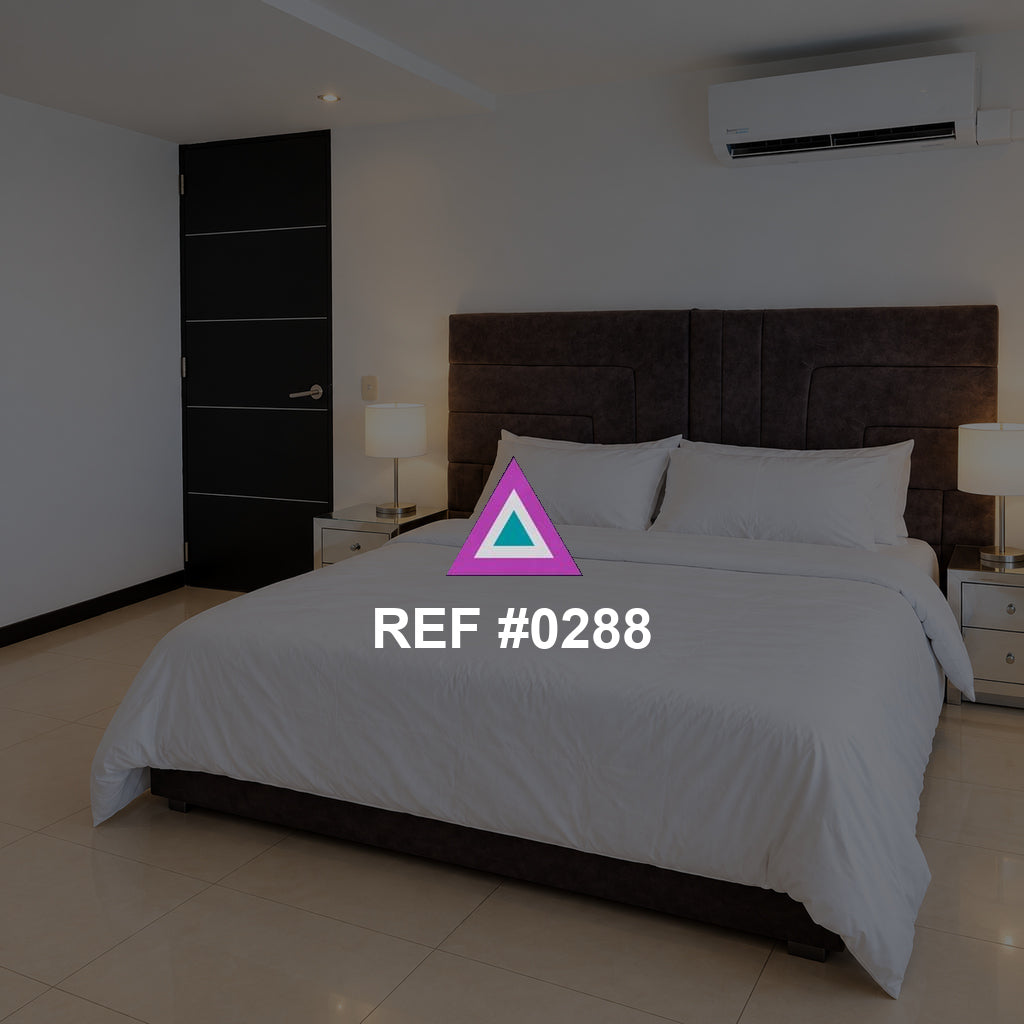 Madera en Blanco. Una cama blanca de cabecera oscura en un dormitorio luminoso con cortinas claras.