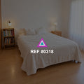 Madera en Flor. Una cama clara con una planta y muebles de madera, iluminada desde el lateral.