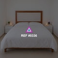 Luz sobre Rosado. Una cama rosada de cabecera de madera entre pequeños muebles claros.