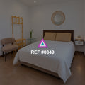 Arena junto al Balcón. Una cama beige con cabecera de madera junto a una puerta de cristal y una planta.