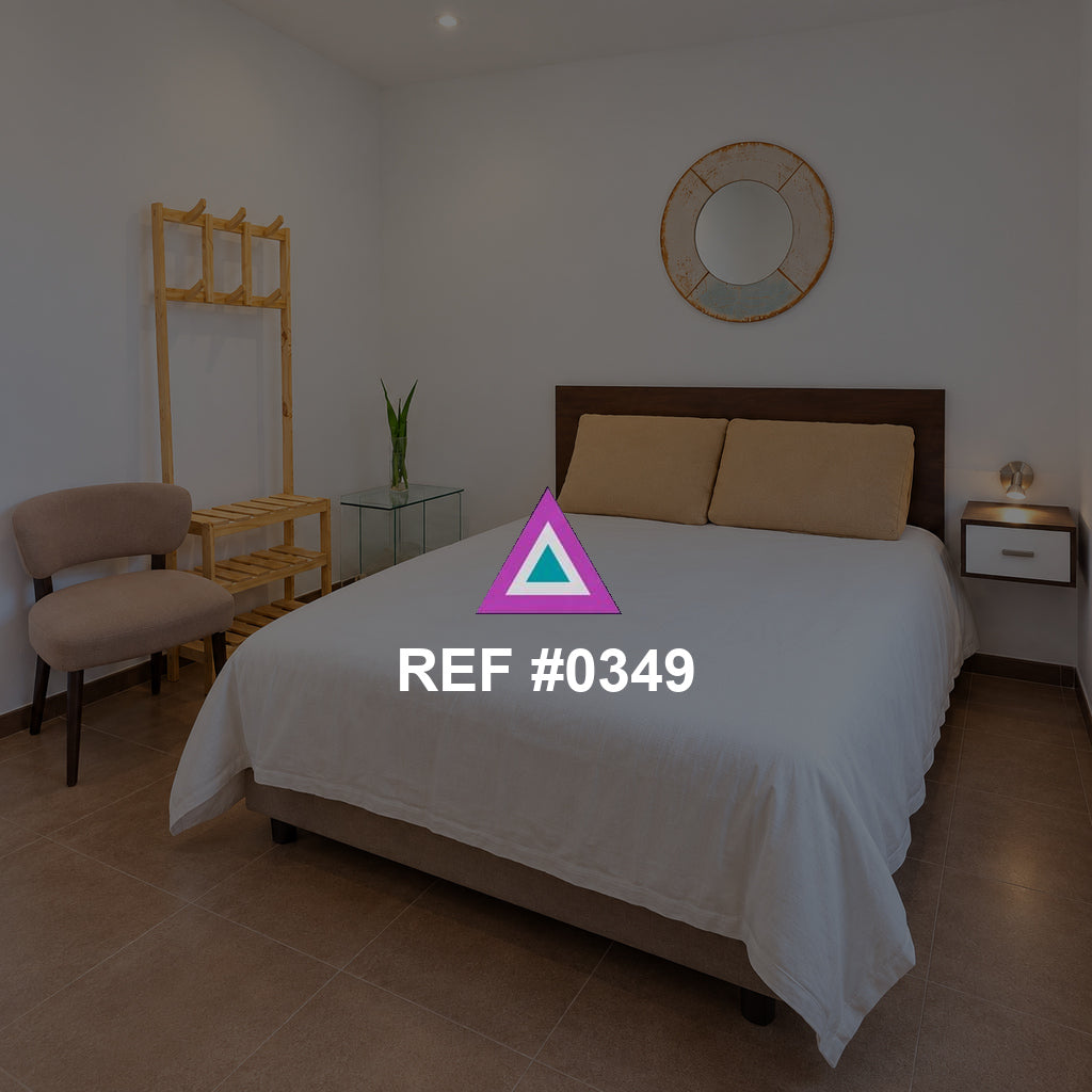 Arena junto al Balcón. Una cama beige con cabecera de madera junto a una puerta de cristal y una planta.