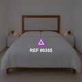 Luz sobre Rosado. Una cama rosada de cabecera de madera entre pequeños muebles claros.