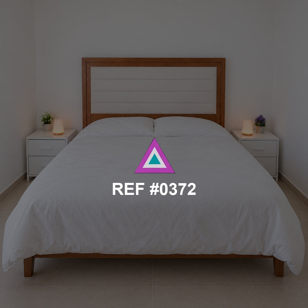 Luz sobre Rosado. Una cama rosada de cabecera de madera entre pequeños muebles claros.
