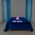 Azul Eléctrico. Una cama de azul intenso frente a cortinas blancas y turquesas.
