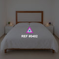 Luz sobre Rosado. Una cama rosada de cabecera de madera entre pequeños muebles claros.